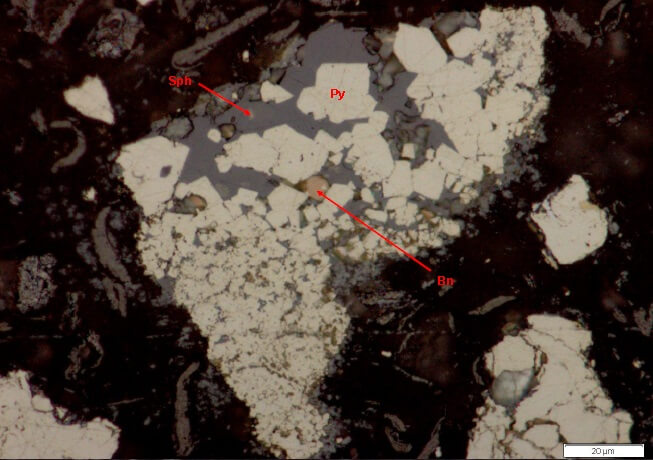 Photomicrograph showing pyrite attached to and locked in sphalerite. Bornite (Bn) locked in sphalerite (Reflected Light).