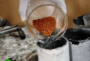 Slowly pour the gold powder into a crucible